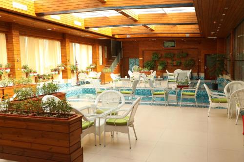 a restaurant with tables and chairs and a pool at Kabul Star Hotel & Restaurant in Shīrpūr