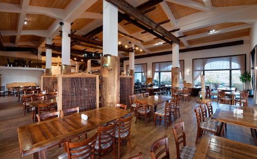 a restaurant with wooden tables and chairs and windows at Wine & Spa Complex Starosel in Starosel
