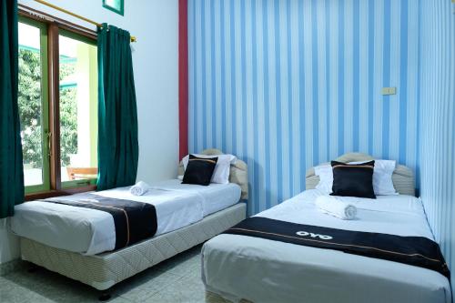 Un pat sau paturi într-o cameră la OYO 2186 Esbe Hotel Syariah