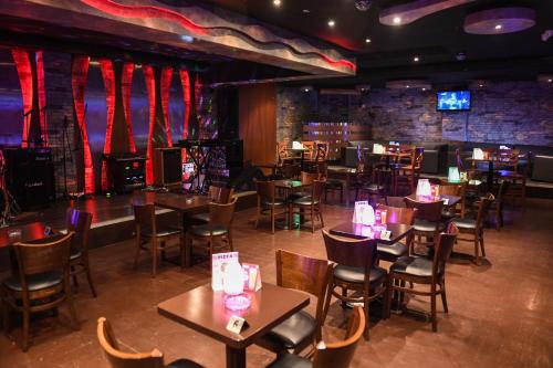 a restaurant with tables and chairs and a bar at Juffair Grand Hotel in Manama