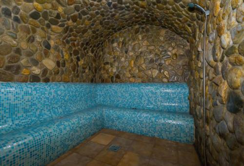 a bathroom with a shower in a stone wall at Hotel Imparatul Romanilor Hotel & SPA in Sibiu