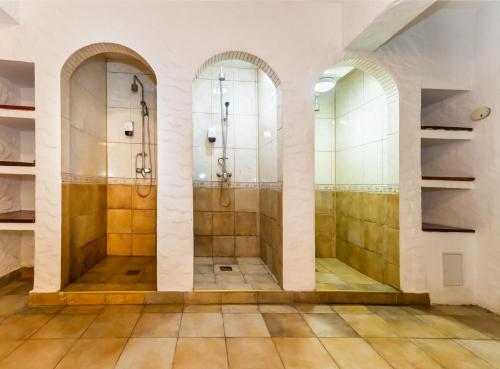 a bathroom with two walk in showers and two mirrors at Hotel Imparatul Romanilor Hotel & SPA in Sibiu
