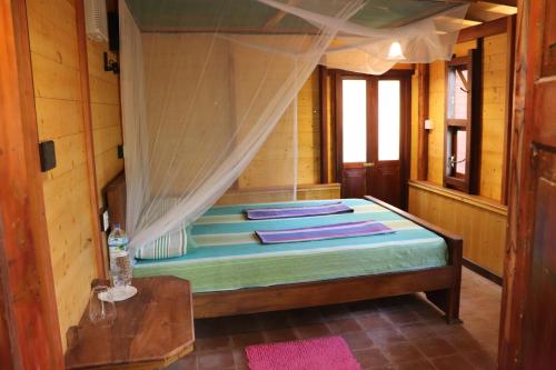 1 dormitorio con 1 cama con dosel en Green Hill Cottage, en Tangalle