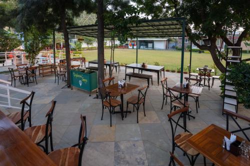 an empty patio with tables and chairs in a park at The G Snoozebox in Udaipur