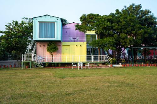 a colorful house with two chairs in a field at The G Snoozebox in Udaipur