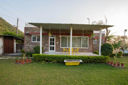 a house with a table and chairs in a yard at The G Snoozebox in Udaipur