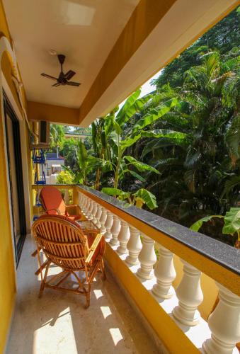 a balcony with two chairs and a ceiling fan at Primavera Holiday Homes-FAMILY RUN GOAN GUEST HOUSE in Candolim