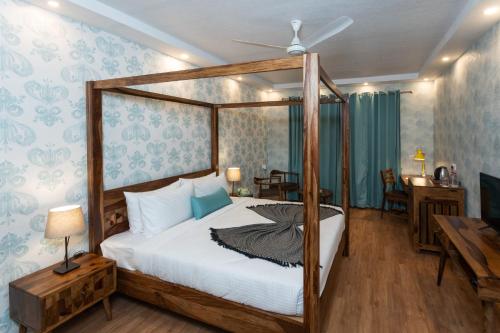a bedroom with a canopy bed and a table at The G Snoozebox in Udaipur
