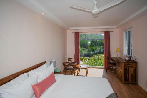 a bedroom with a bed and a window and a desk at The G Snoozebox in Udaipur