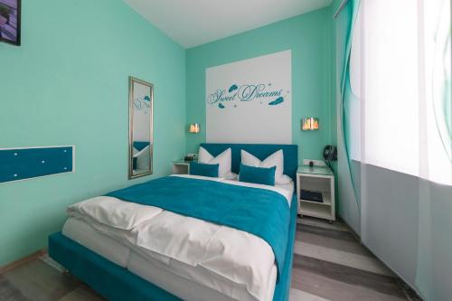 a blue bedroom with a bed with blue walls at Hotel Höhn in Rüdesheim am Rhein