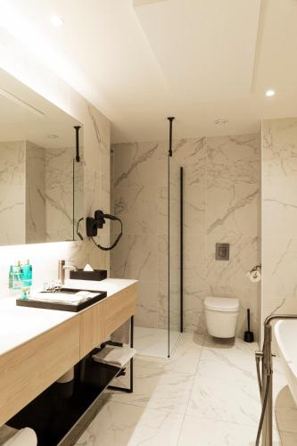 a bathroom with a sink and a shower and a toilet at Corsendonk Turnova in Turnhout