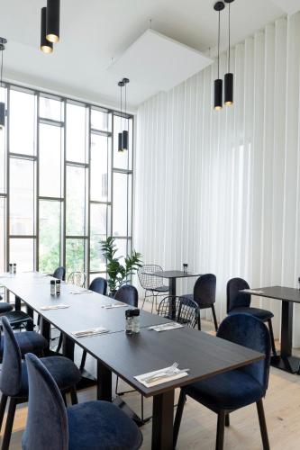 a row of tables and chairs in a room with windows at Corsendonk Turnova in Turnhout