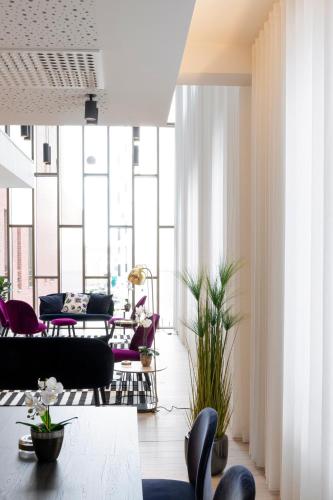 a living room with purple furniture and large windows at Corsendonk Turnova in Turnhout