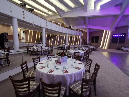a banquet hall with white tables and chairs and purple lighting at Wine & Spa Complex Starosel in Starosel