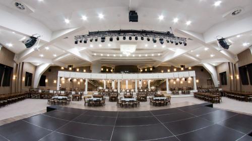 an empty concert hall with a stage and tables and chairs at Wine & Spa Complex Starosel in Starosel