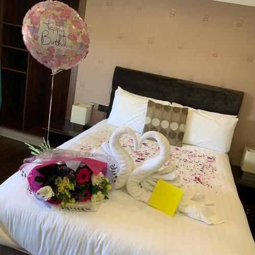 a bed with two swans and flowers and a balloon at The Kings Arms Hotel in Berwick-Upon-Tweed
