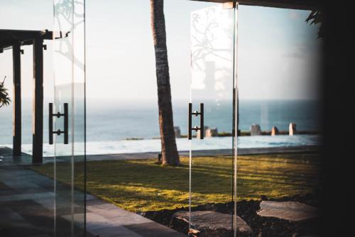 a view of the beach through a glass wall at The Istana in Uluwatu