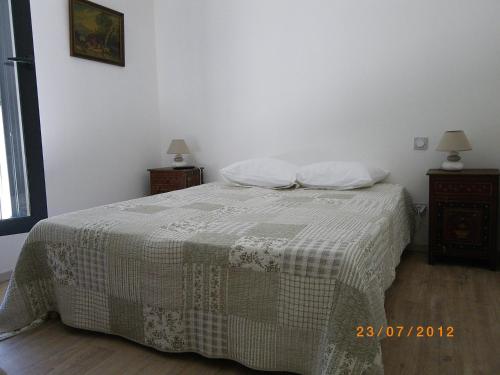 a bedroom with a bed with a blanket and two night stands at Les Algues du Grau in Le Grau-dʼAgde