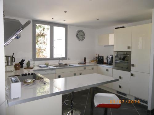 a white kitchen with a sink and a window at Les Algues du Grau in Le Grau-dʼAgde