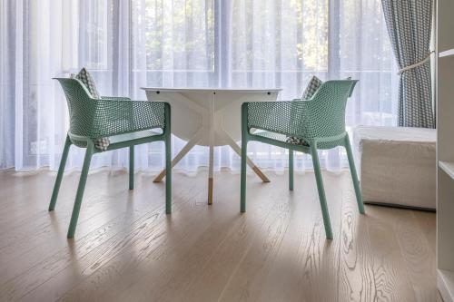 two green chairs and a table in a room at Mint Studio in Druskininkai