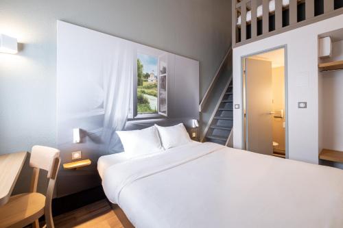 Un pat sau paturi într-o cameră la B&B HOTEL Lille Seclin