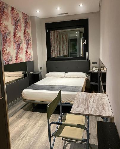 ウマネス・デ・マドリードにあるHotel Fabrikのベッドとテーブルと椅子のあるホテルの部屋