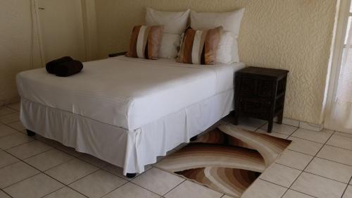 a bed in a room with a floor in the floor at Moye Guest House in Benoni