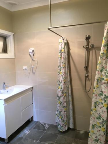 a bathroom with a shower, sink, and toilet at Poplars Inn Mittagong in Mittagong