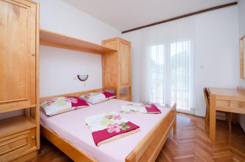 a bedroom with a bed and a large window at Apartments Joka in Lopar