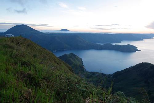 a van on top of a hill overlooking a body of water at Hotel Sibayak Internasional in Berastagi