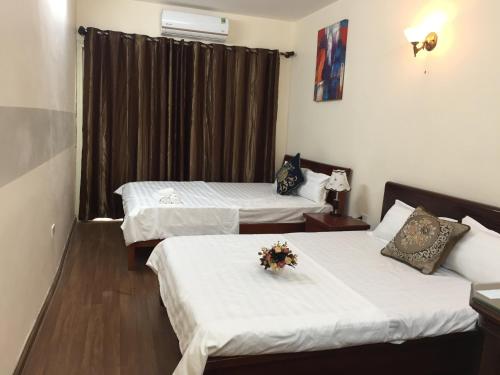 una habitación de hotel con 2 camas con flores. en Melody home, en Hanói