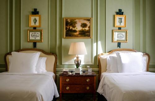 a hotel room with two beds and a table with a lamp at Four Seasons Hotel Firenze in Florence