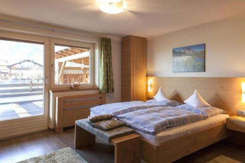 a bedroom with a bed and a large window at Appartements Pfister in Fügen