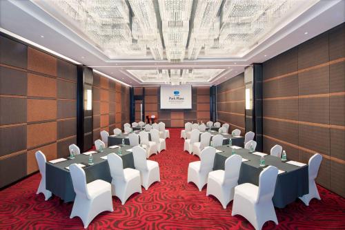 a room with rows of tables and white chairs at Park Plaza Beijing Science Park in Beijing