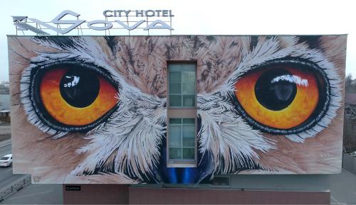 un mural de un búho en el lateral de un edificio en City Hotel Sova, en Nizhny Novgorod
