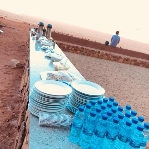 a table with blue and white plates and water bottles at Desert Bedouin camp in Wadi Rum