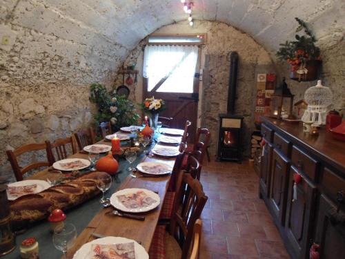 a dining room with a long table in a stone building at La Tour de Seythenex in Seythenex