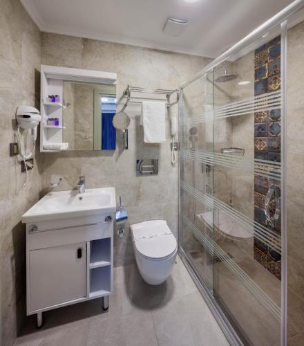 a bathroom with a shower and a toilet and a sink at OBAHAN HOTEL-Special Class in Istanbul