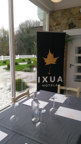a table with wine glasses and a sign with a maple leaf at IXUA Hotela in Éibar