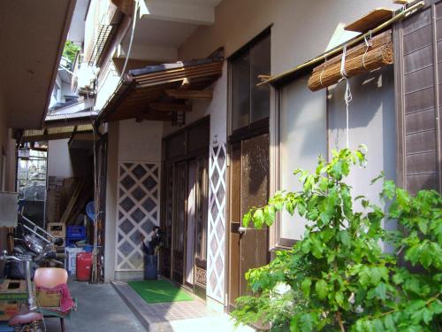 a building with a door and a plant in front of it at Ishibu-so in Matsuzaki