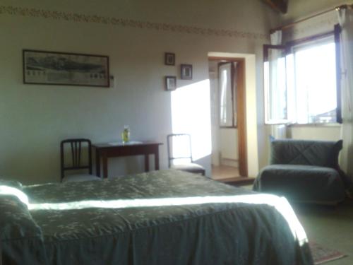 a bedroom with a bed and a chair and a table at Locanda Stella D'oro in Quinto di Treviso