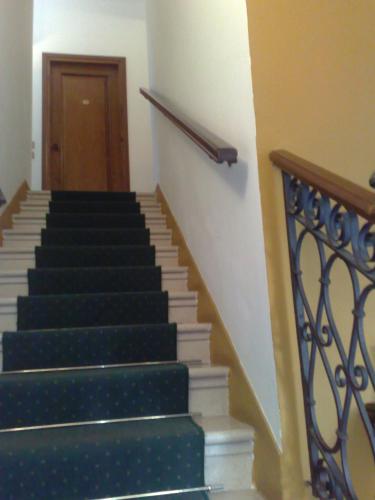 a staircase with green and white stairs with a door at Locanda Stella D'oro in Quinto di Treviso