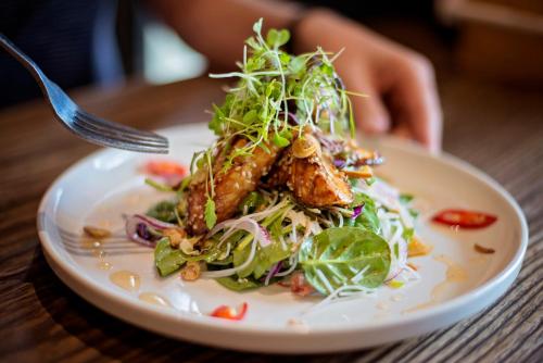 a plate of food with a salad on a table at Six Degrees Boutique Hotel in Albany