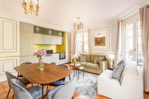 een woonkamer met een tafel en een bank bij Luxury 2 Bedroom With Balcony - Louvre & Notre Dame in Parijs