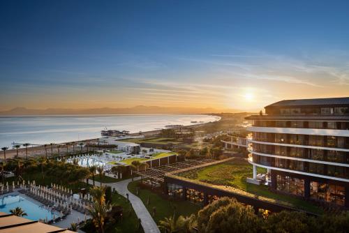 a view of a hotel and the ocean at sunset at Voyage Belek Golf & Spa Hotel in Belek