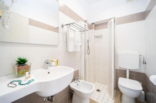 a white bathroom with a sink and a toilet at Hotel Abc in Cervia