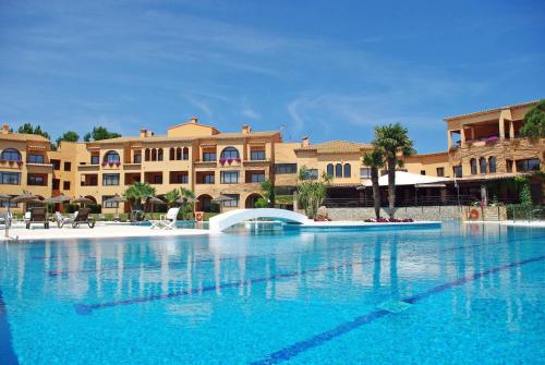 uma grande piscina em frente a alguns edifícios em La Costa Hotel Golf & Beach Resort em Pals