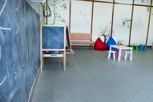 ポルトノボにあるCamping Baltarの黒板、テーブル、椅子が備わる教室