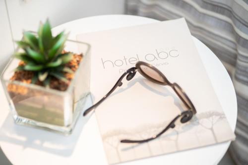 a pair of glasses sitting on a table with a book at Hotel Abc in Cervia