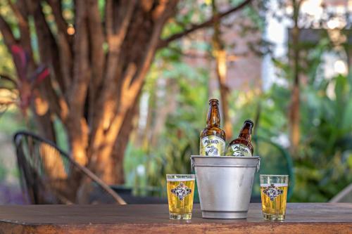 Tre bottiglie di birra in un secchio su un tavolo di Suítes no Quintal a Brotas